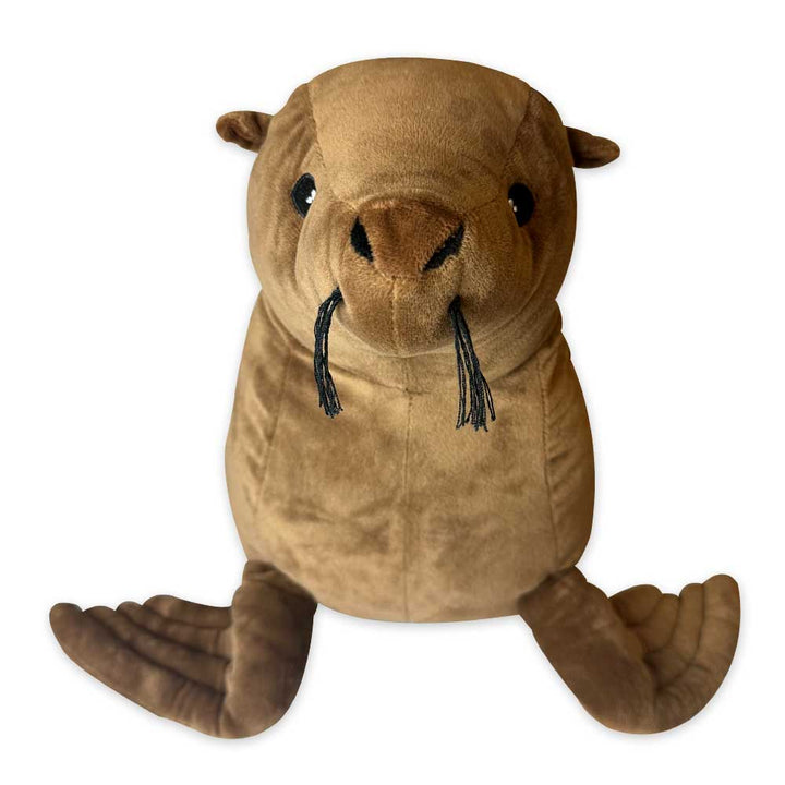 The Earth Pal Sea Lion Plush, made from eco-friendly recycled materials, features brown plush fabric, black tusks, large black eyes, small ears, and flipper-like limbs while sitting upright against a white background.