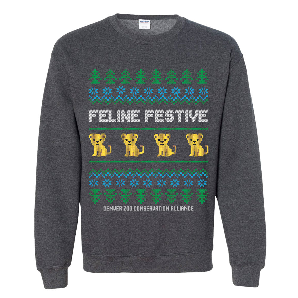 The DZCA Feline Festive Crew Sweatshirt is a dark gray top featuring yellow cartoon lions, green trees, blue snowflakes, and the phrases FELINE FESTIVE and DENVER ZOO CONSERVATION ALLIANCE in a holiday conservation design.
