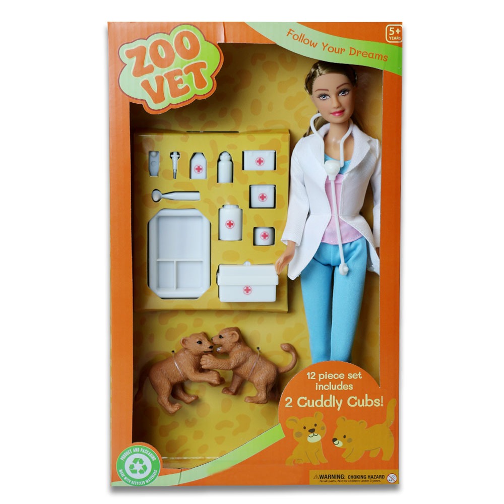 The Eco Zoo Vet Doll playset features a female zoo vet in a white coat, two lion cubs, medical accessories, and a white vet bag. Packaged in orange Zoo Vet packaging labeled "12 piece set includes 2 cuddly cubs!" Eco-friendly box.