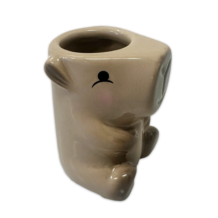The Capybara 3D Shot Glass is a beige ceramic cup shaped like a sitting capybara. It features a simple black mouth and nose design with a round opening at the top, perfect for novelty drinks. The background is plain white.