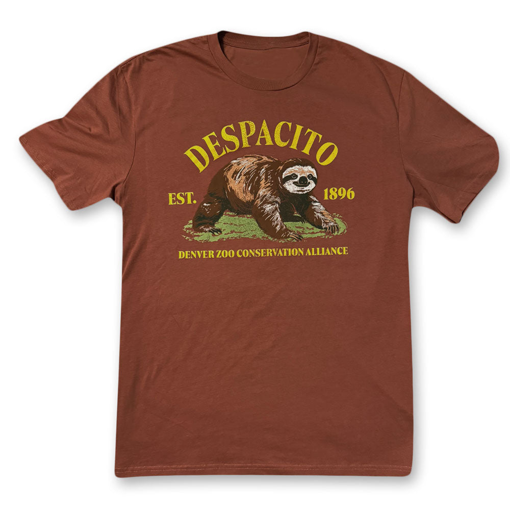 The DZCA Despacito Sloth T-Shirt is brown with a sloth illustration and yellow text, featuring "DESPACITO EST. 1896" and "DENVER ZOO CONSERVATION ALLIANCE" below—ideal for sloth fans and nature lovers.