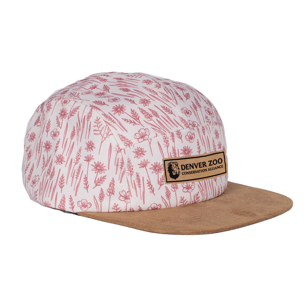 The DZCA x Jack and Sage Wild Flowers Cap is a white and pink hat with a brown suede brim, featuring a rectangular patch that reads "Denver Zoo Conservation Alliance" on the front.