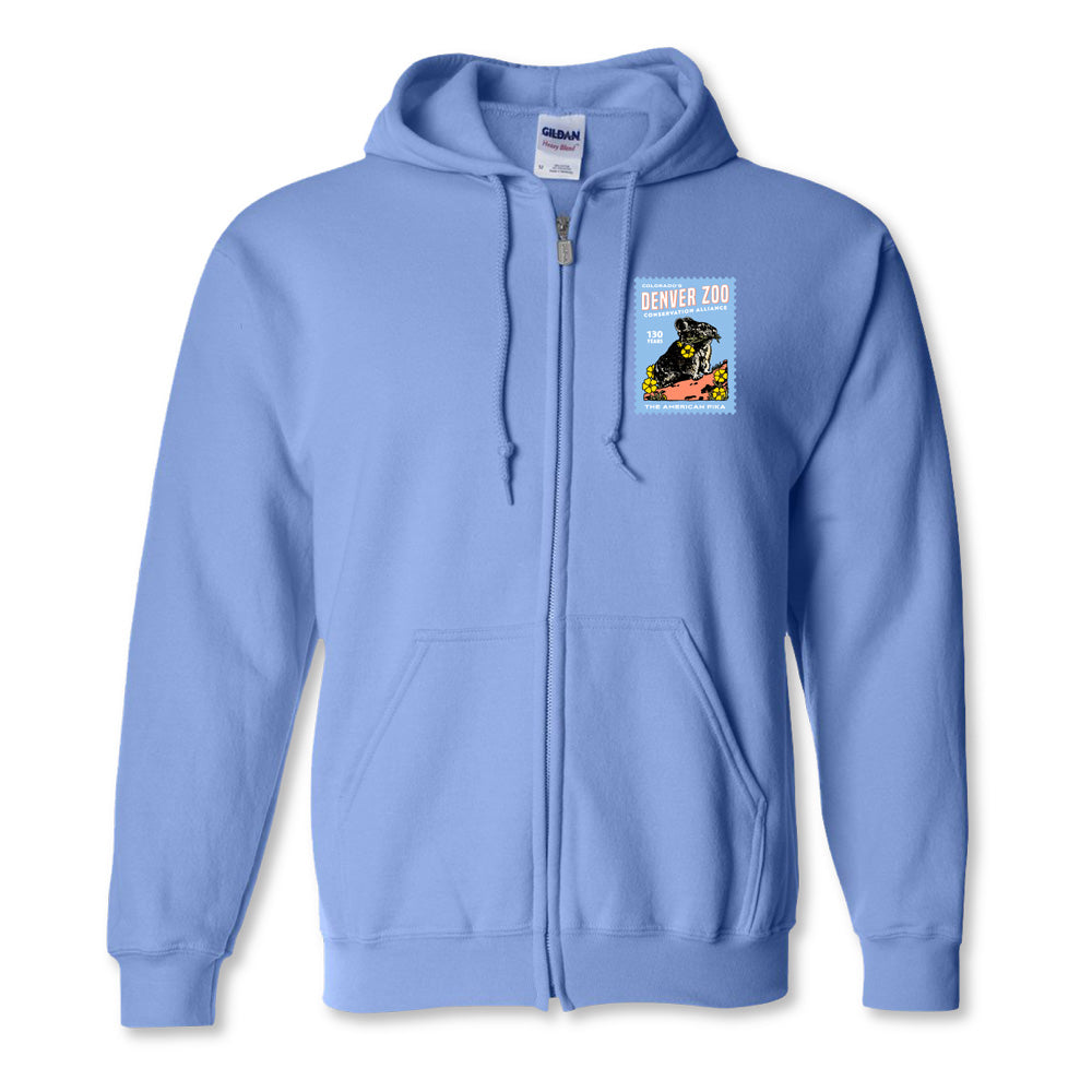 The DZCA 130th Anniversary Pika Hooded Zip Sweatshirt in light blue features a small, colorful Denver Zoo patch with a rhinoceros and stylized text on the left chest, finished with a unique stamp-like border.