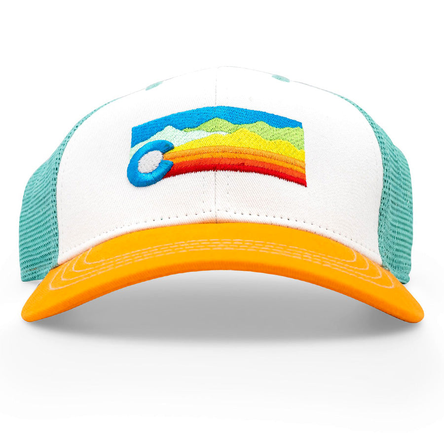 The Low Pro CO Scape Trucker Hat features a white front, aqua mesh sides, and yellow brim with a colorful mountain landscape patch in a C shape and rainbow stripes. Streamlined fit, one size fits most.