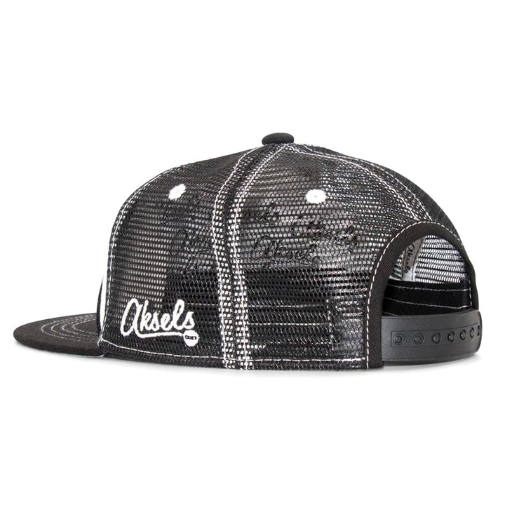 The Kids Penguin Flat Brim Hat is a black mesh snapback with white stitching and Aksels embroidered in white on the side. Seen from the back, it highlights an adjustable strap and ventilation holes for comfort.