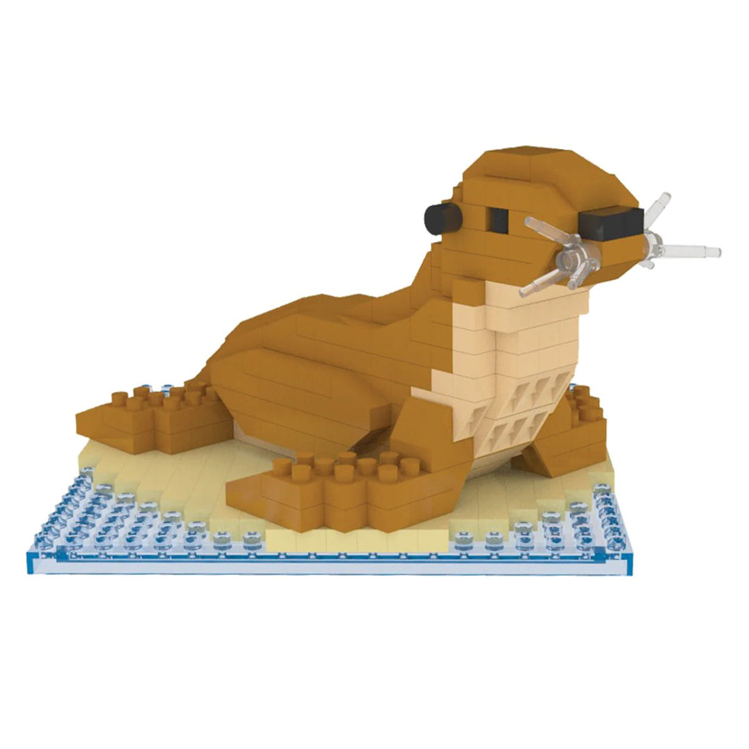 The Sea Lion Mini Building Blocks set includes 277 non-toxic ABS pieces in brown, tan, and white to create a detailed sea lion figure with clear whiskers and black eyes, sitting on a water and sand base.