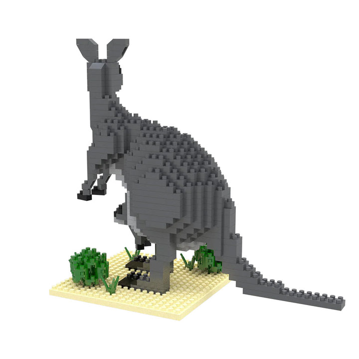 The Mini Building Blocks Kangaroo features a grey kangaroo with long tail and ears, standing on a tan base with green shrubs. This portable set lets you build a pixelated kangaroo facing away for display or play.