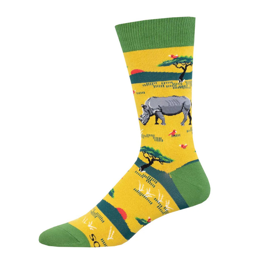 Rhinoceros Crew Socks feature a gray rhino, green trees, and a vibrant landscape on a yellow background with red accents. Made from comfortable cotton, these colorful socks celebrate wildlife preservation in playful style.
