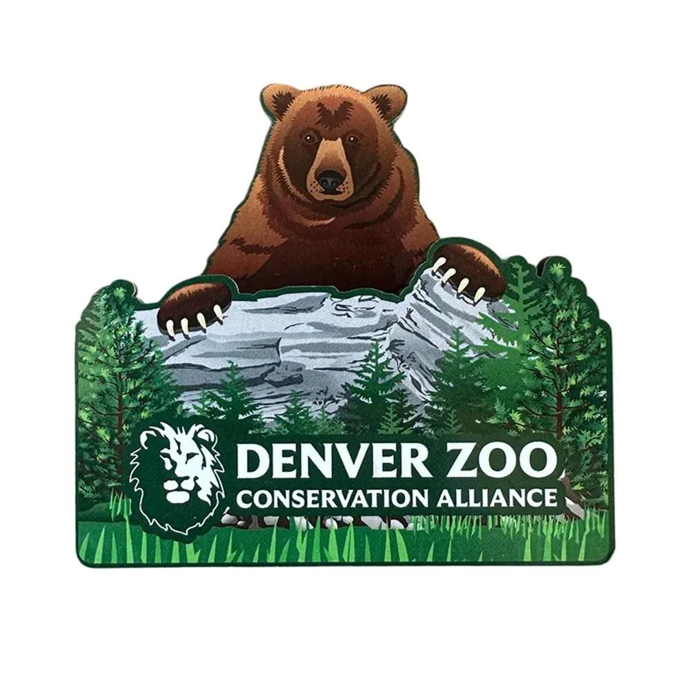 DZCA Bear Pop-up Magnet: Features a bear standing behind a rock amid green trees, with "Denver Zoo Conservation Alliance" text and a lion logo on the left. Ideal for wildlife home décor lovers.