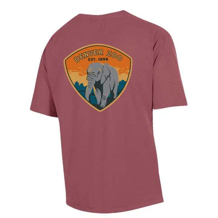The Denver Zoo Elephant Patch T-Shirt is a mauve short-sleeve tee made from soft US-grown ringspun cotton, featuring a large shield-shaped back logo with an elephant, trees, and sunset. Text: DENVER ZOO EST. 1896.
