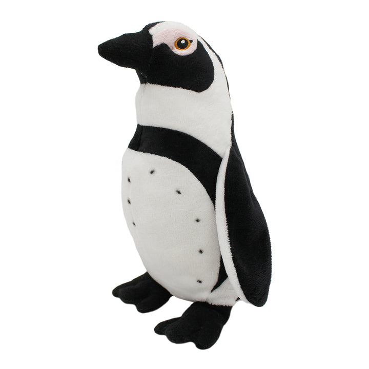 The Eco Pals Black-Footed Penguin Plush is a black and white plush toy with black feet and beak, orange and black eyes, small black spots on its white body, shown standing upright against a white background.