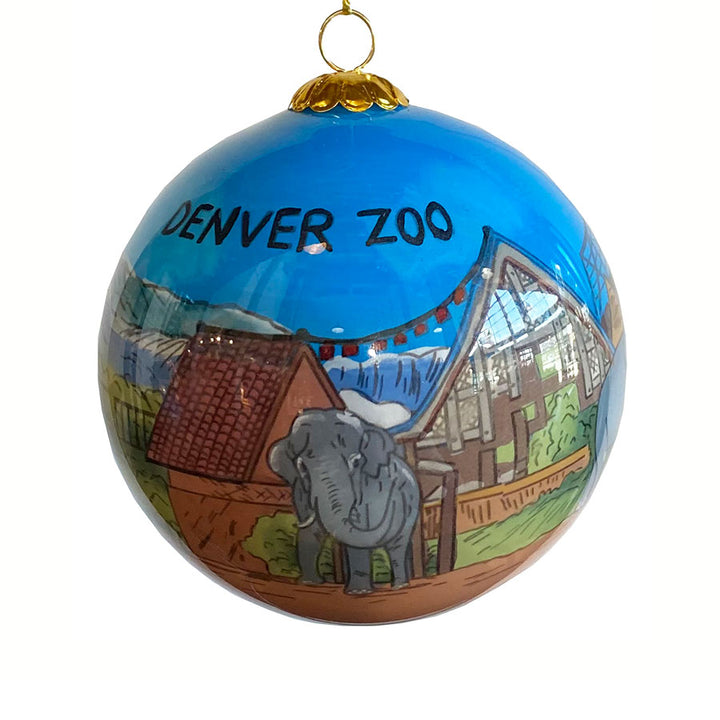 The Denver Zoo Elephant Ornament is a blue Christmas ornament showcasing an elephant, buildings, and mountains, with “DENVER ZOO” at the top.