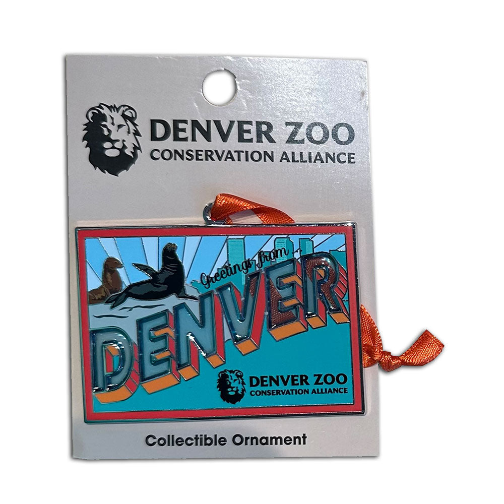 The DZCA Sea Lions Greeting Stained Glass Ornament is a rectangular ornament with "Greetings from DENVER," sea lions, and Denver Zoo logos, packaged by Denver Zoo Conservation Alliance and accented with an orange ribbon.